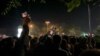 A Bishkek police official tries to calm protesters near a dorm for foreign students in the Kyrgyz capital on the night of May 17-18.