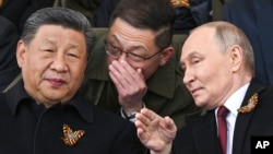 Президент России Владимир Путин (справа) и лидер Китая Си Цзиньпин на военном параде в Москве, 9 мая 2025 года