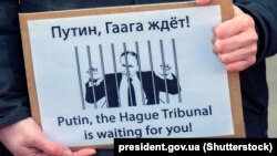 Нидерланды. Плакат «Путин, Гаагский трибунал ждет тебя!» на акции против агрессии России по отношению к Украине. Амстердам, 6 марта 2022 года