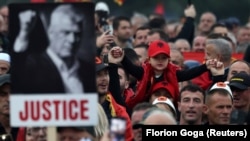Një protestues mban fotografinë e ish-presidentit të Kosovës, Hashim Thaçi, gjatë një proteste në Tiranë, Shqipëri, në mbështetje të ish-eprorëve të UÇK-së, të cilët po gjykohen në Hagë, 17 tetor 2025.