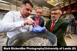 Ukrainian academics Oleksii Hunyak (left) and Taras Markiv (center), and British academic Leon Black, inspect fragments of recycled concrete in Leeds.