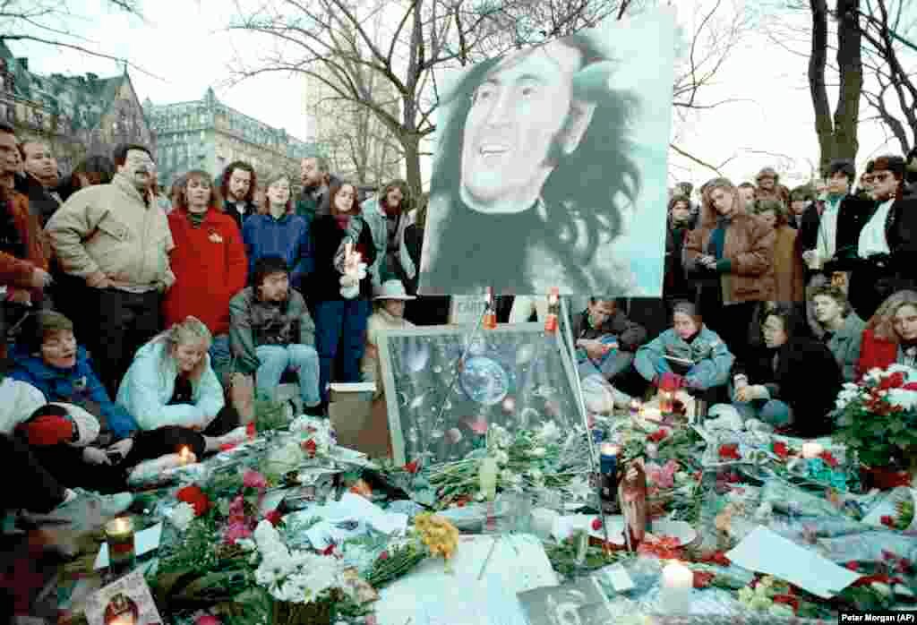 Люди собрались на «Strawberry Fields» в Центральном парке в десятую годовщину со дня убийства Джона Леннона, 8 декабря 1990 года. На заднем плане – многоквартирный дом «Дакота», где Леннон жил со своей семьей