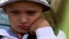 An image shows 6-year-old Damir waiting to be evacuated from his grandfather's house in Dnipropetrovsk region.