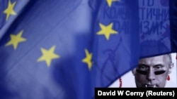 A poster depicting Russian President Vladimir Putin is seen behind an EU flag during a rally by the Czech Republic's Ukrainian community following Russia's invasion of Crimea, in Prague in 2014.